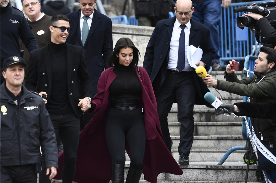 Juventus' forward and former Real Madrid player Cristiano Ronaldo leaves with his Spanish girlfriend Georgina Rodriguez after attending a court hearing for tax evasion in Madrid on January 22, 2019. - Ronaldo is expected to be given a hefty fine after Spanish tax authorities and the player's advisors made a deal to settle claims he hid income generated from image rights when he played for Real Madrid. (Photo by PIERRE-PHILIPPE MARCOU / AFP)