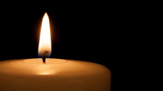 White candle on black background with copy space for text