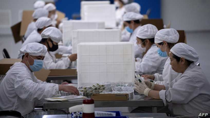 Workers package rabies vaccine at a lab at the Yisheng Biopharma company, where researchers are trying to develop a vaccine for the COVID-19 coronavirus, in Shenyang, in China's northeast Liaoning province, on June 9, 2020. - China has mobilised its army and fast-tracked tests in the global race to find a coronavirus vaccine, and is involved in several of the dozen or so international clinical trials currently under way. (Photo by NOEL CELIS / AFP)
