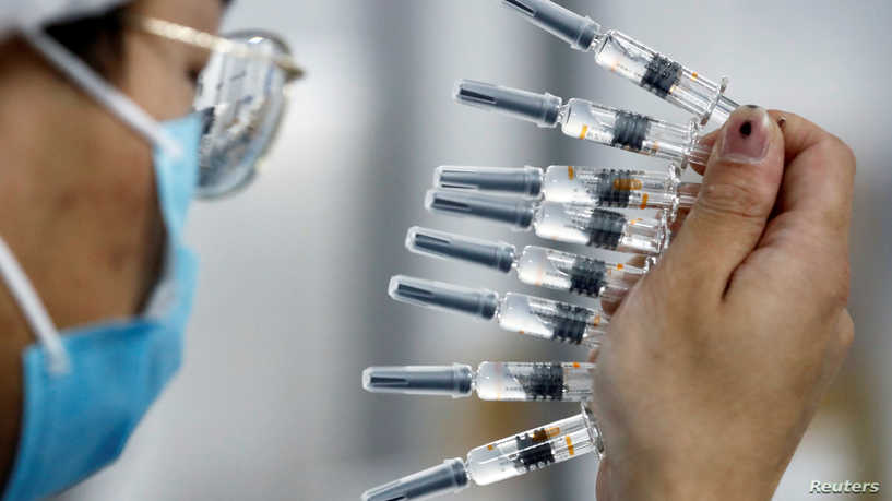 FILE PHOTO: A worker performs a quality check in the packaging facility of Chinese vaccine maker Sinovac Biotech, developing an experimental coronavirus disease (COVID-19) vaccine, during a government-organized media tour in Beijing, China, September 24, 2020. REUTERS/Thomas Peter/File Photo