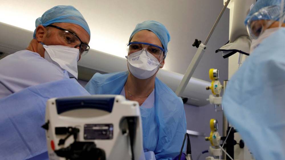 Medical workers, wearing protective gear, work in the Intensive Care Unit (ICU) where coronavirus disease (COVID-19) patients are treated at Cambrai hospital, France, March 25, 2021. Picture taken March 25, 2021. REUTERS/Pascal Rossignol