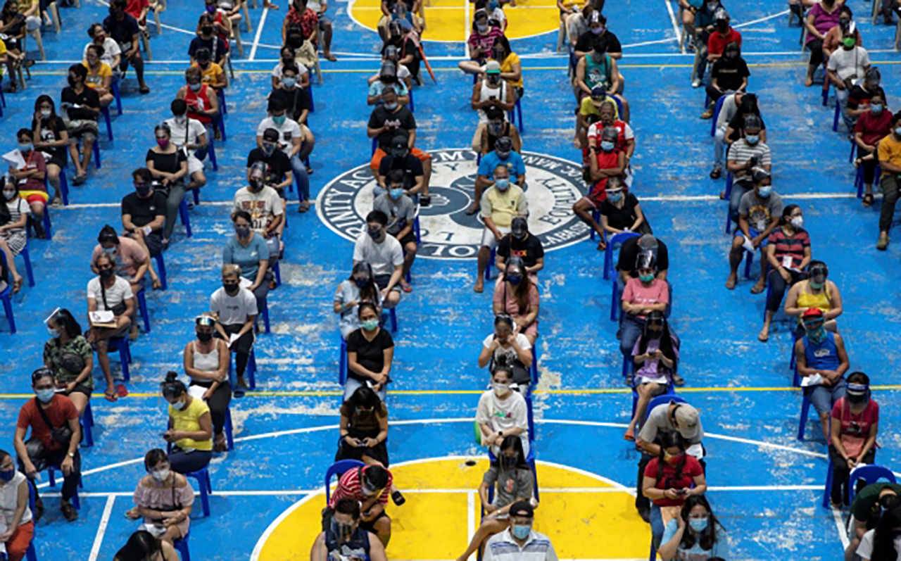 Filipinos queue to get Moderna COVID-19 vaccine in a school turned vaccination site that operates 24/7, in Manila, Philippines, August 9, 2021. REUTERS/Eloisa Lopez
