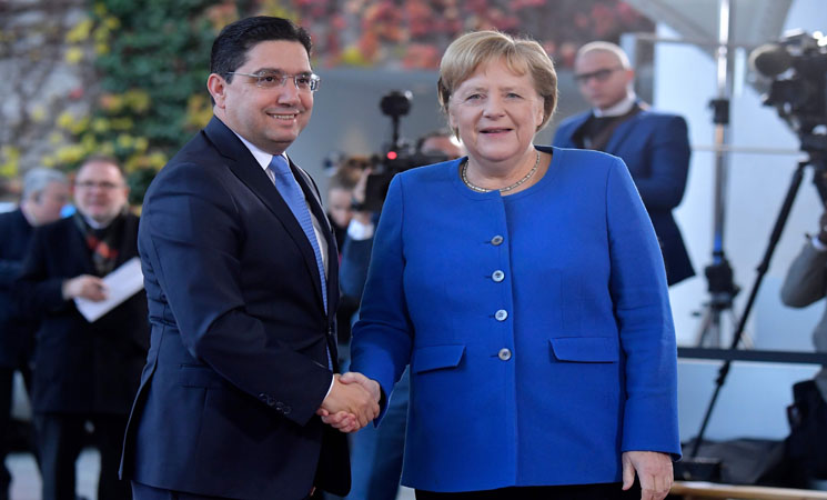 German Chancellor Angela Merkel welcomes Morocco's Foreign Minister Nasser Bourita upon his arrival for the G20 Compact with Africa (CwA) conference on November 19, 2019 in Berlin. - Heads of State and Government of all Compact countries and the Heads of International Organizations participating in the CwA are expected to discuss opportunities to enhance the business environment and increase investment in African countries. (Photo by Tobias SCHWARZ / AFP)